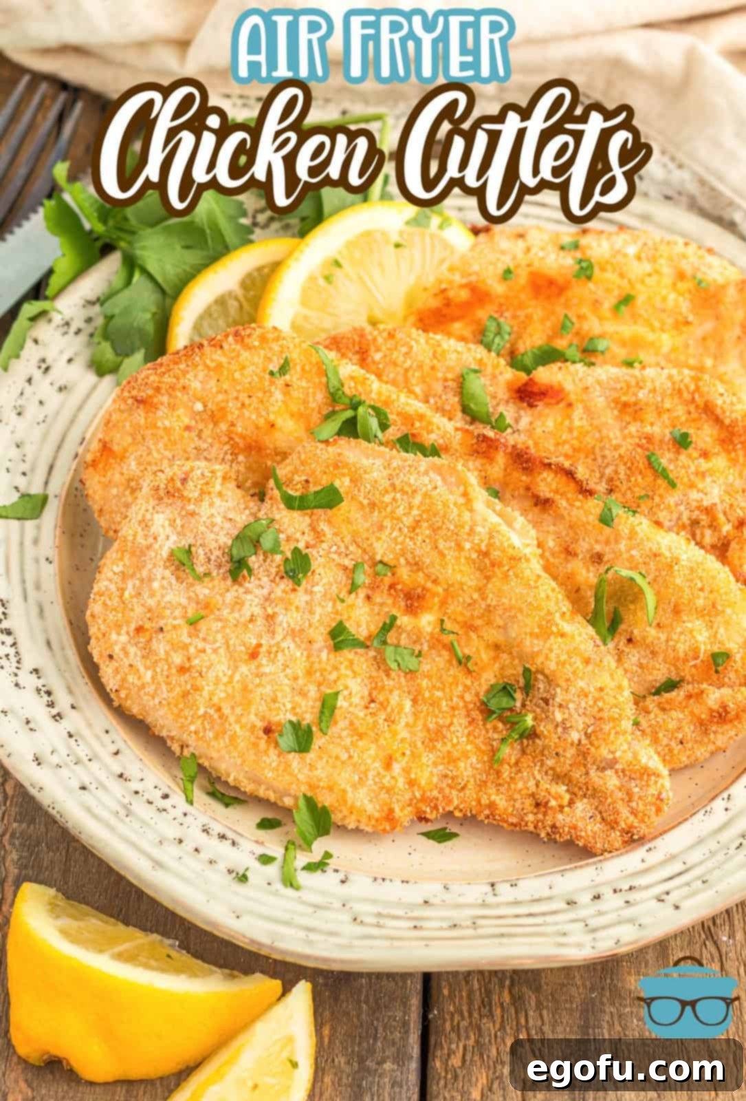 Pinterest image of layered Air Fryer Chicken Cutlets on plate with lemon wedges.
