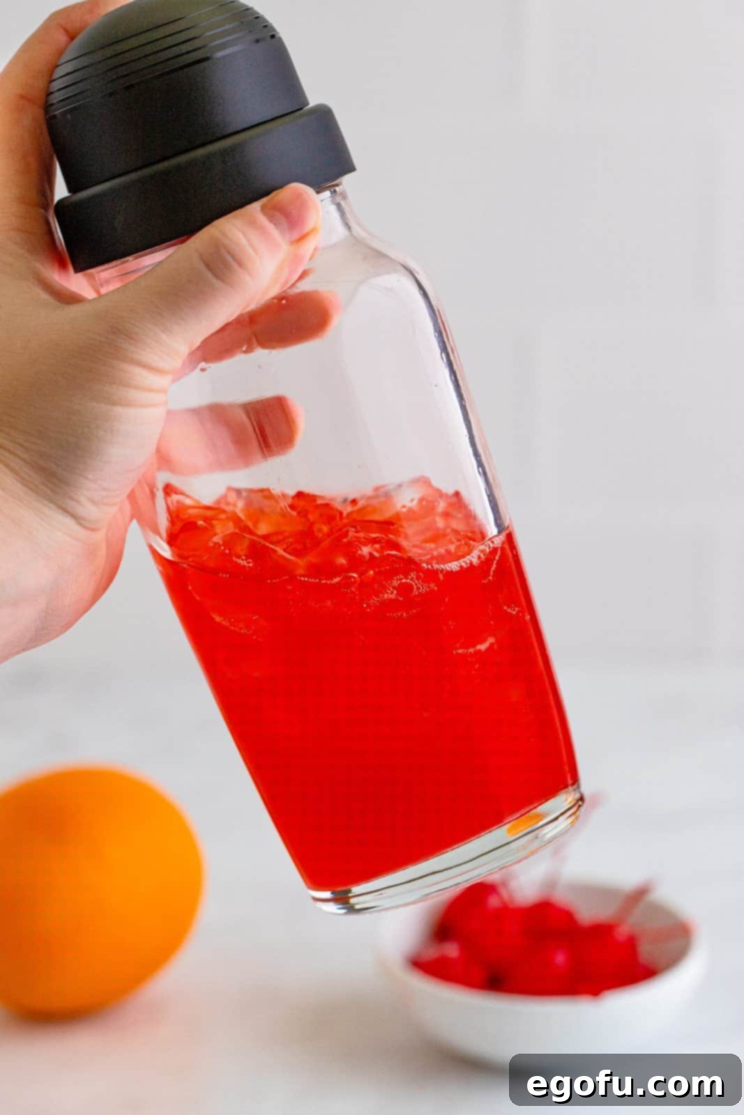 Dixie Dynamite 5 A cocktail shaker being vigorously shaken to mix the drink.