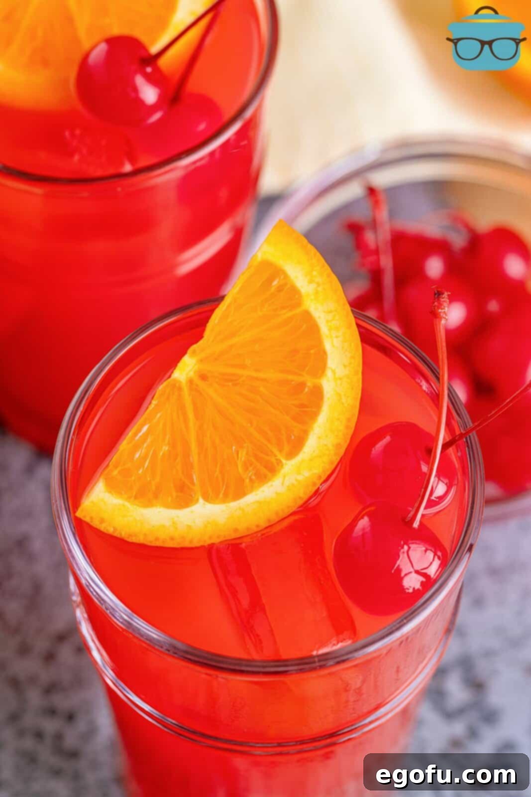 Dixie Dynamite 6 An overhead view of a beautifully garnished Alabama Slammer cocktail with orange slices and maraschino cherries.