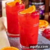 Dixie Dynamite 7 Close up image of Alabama Slammer on metal tray garnished with orange and cherry.