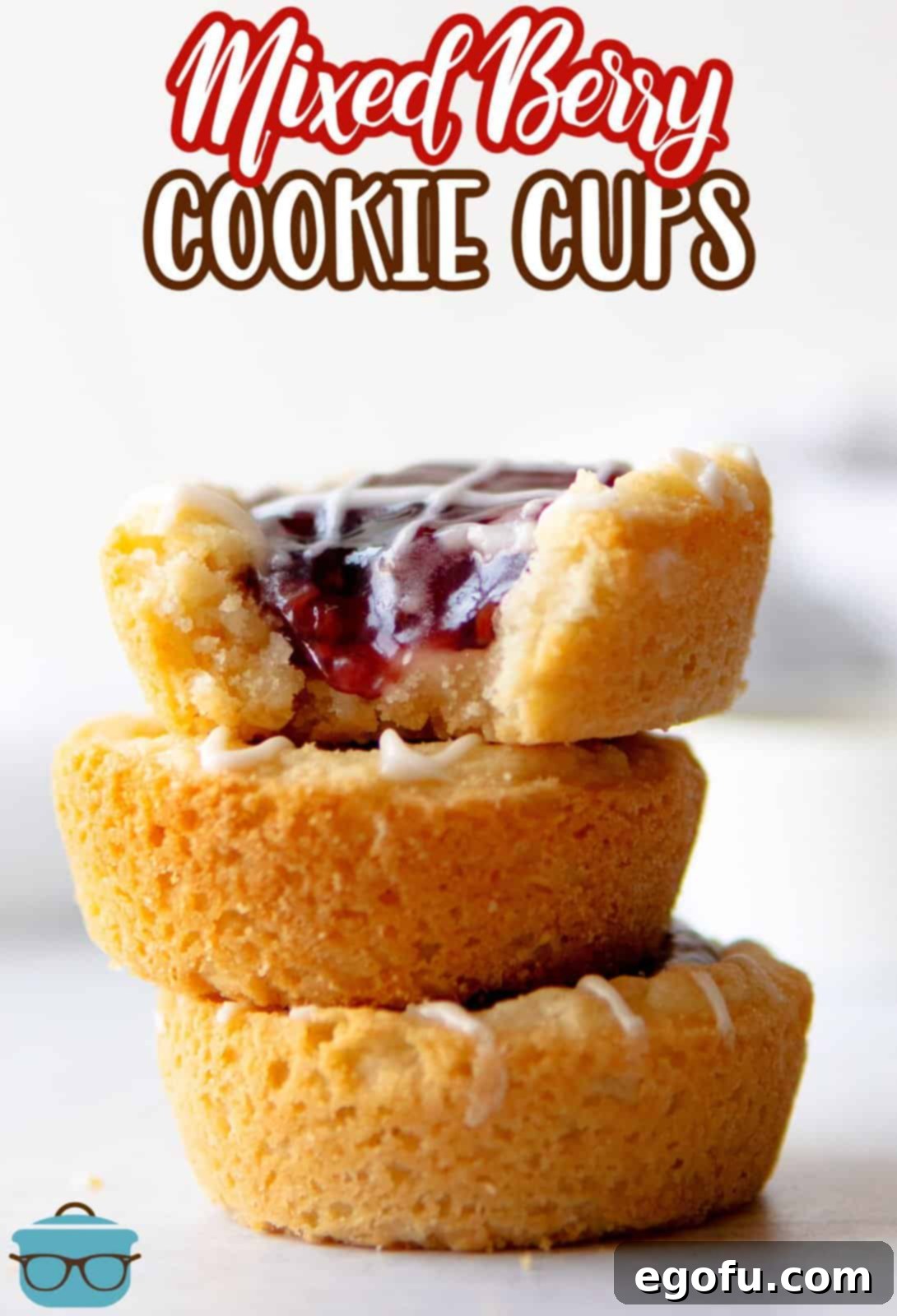 Berry Burst Cookie Cups 3 A stack of golden-baked Berry Cookie Cups, with one on top showing a delightful bite taken out, revealing the rich berry filling.