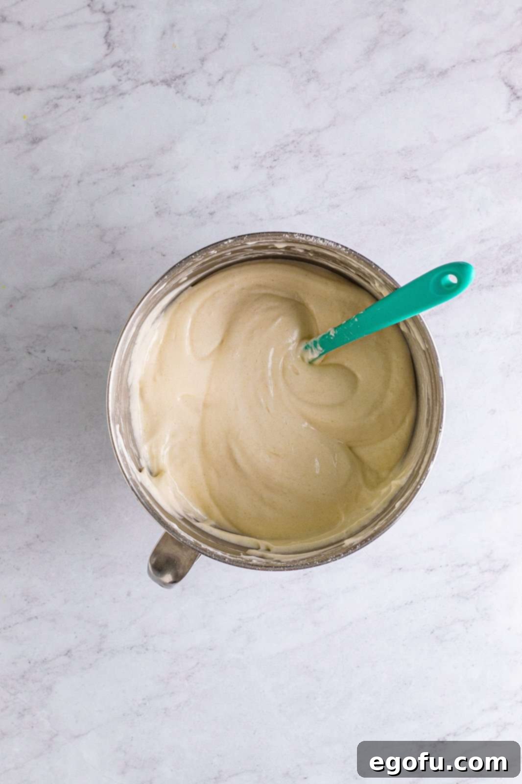 Cake ingredients gently folded together in a stand mixer bowl.