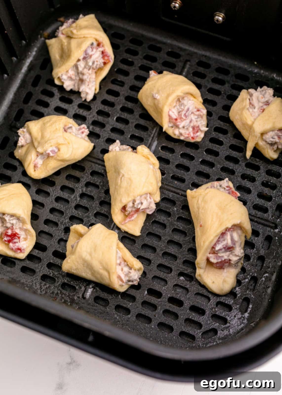 Crescent rolls added to air fryer basket.