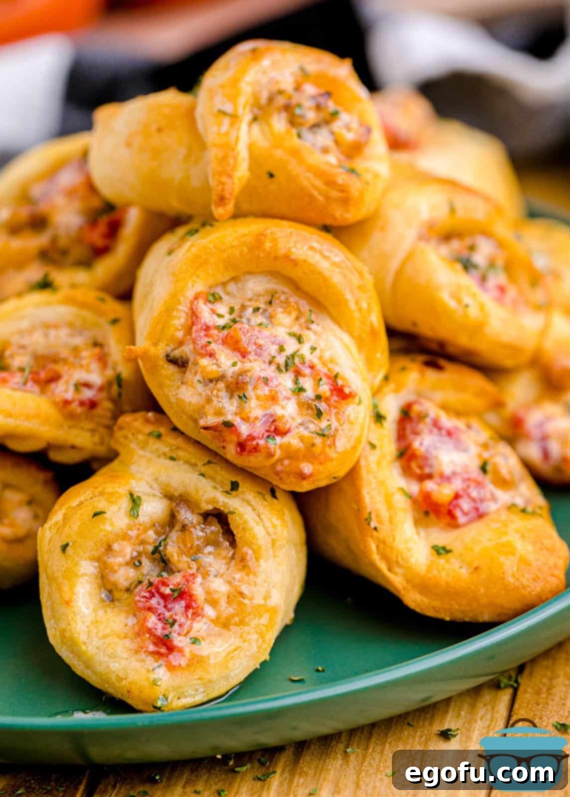 Air Fryer Sausage and Cream Cheese Crescents on plate stacked showing filling.