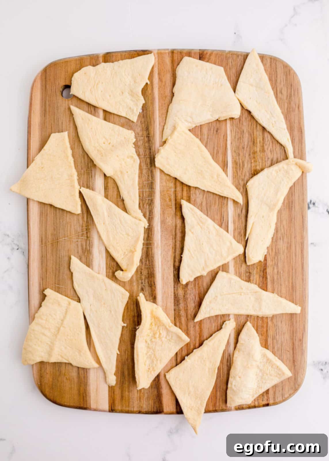Crescent rolls cut on cutting board.