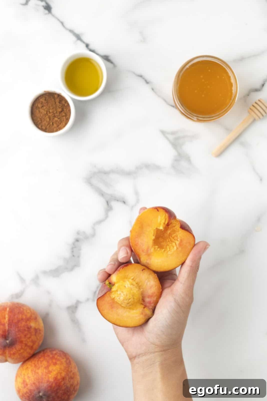 Peaches being cut in half, showcasing the proper technique for pitting.