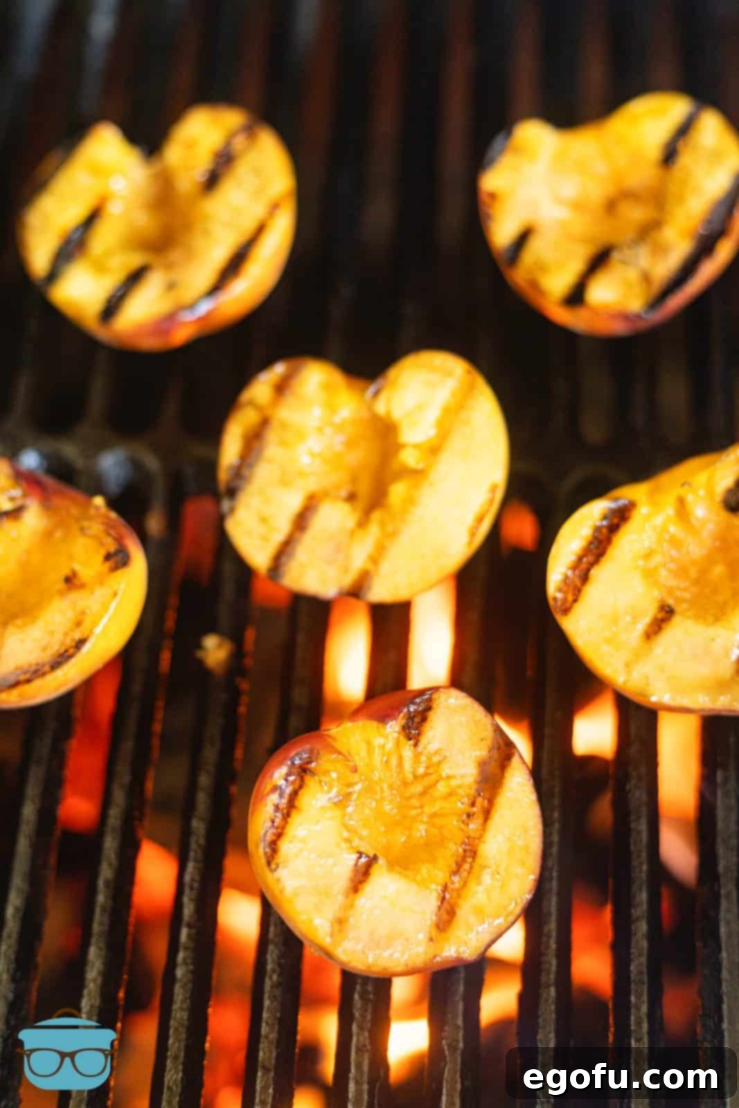 Cut side of peaches up on grill, showing second grilling stage and developing tenderness.