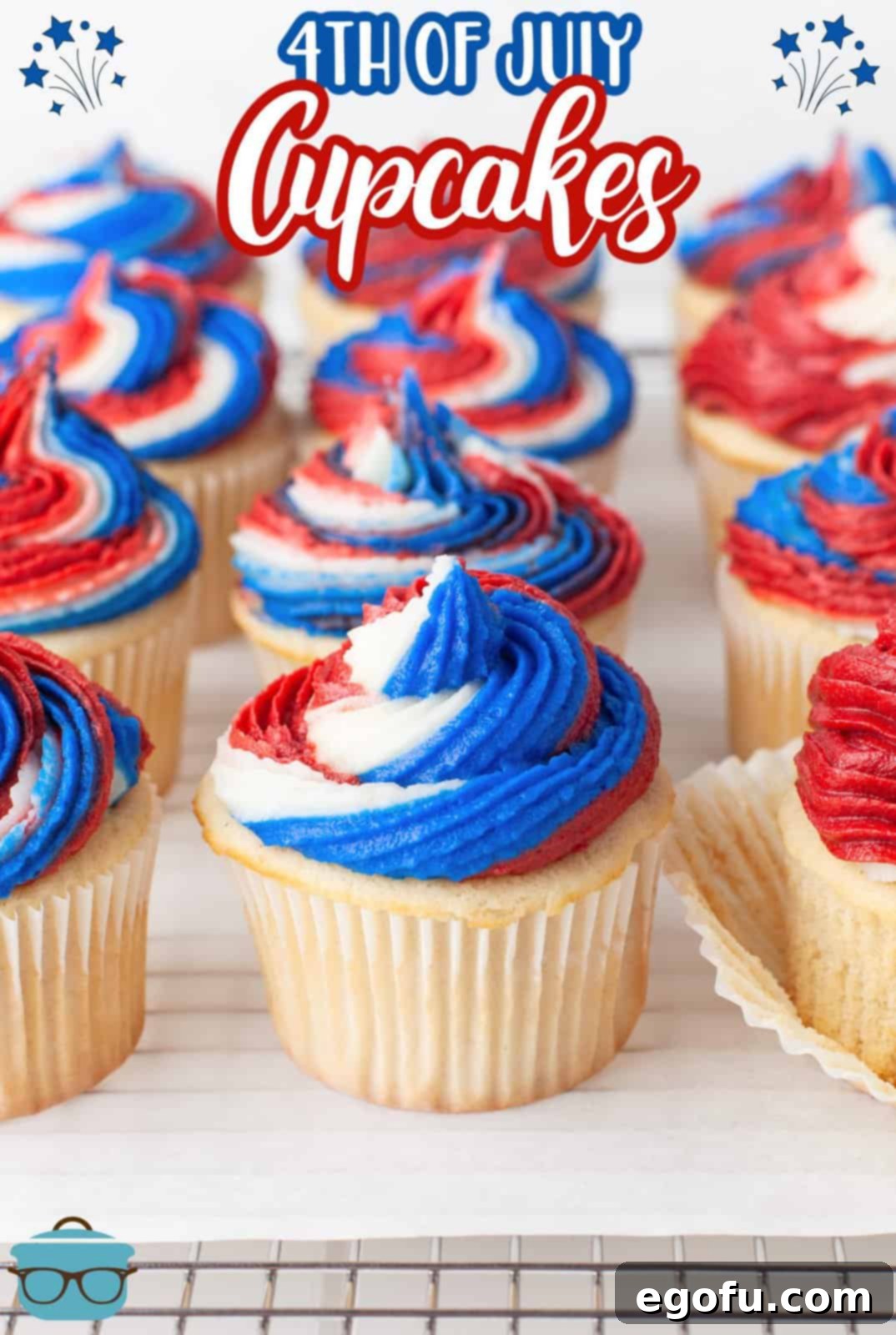 Pinterest image close up of 4th of July Cupcakes on parchment over wire rack in rows.
