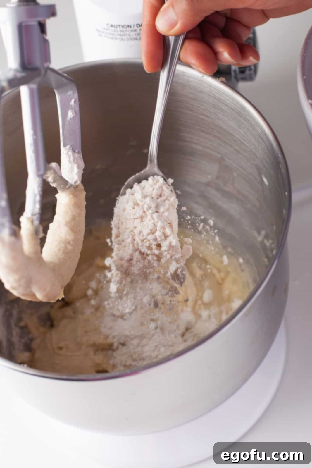 Sifted dry ingredients being added to stand mixer.