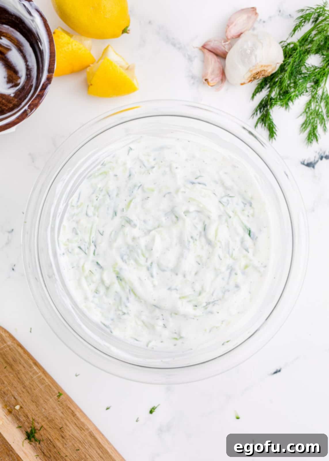 Tzatziki sauce stirred together in a bowl, creamy and ready.