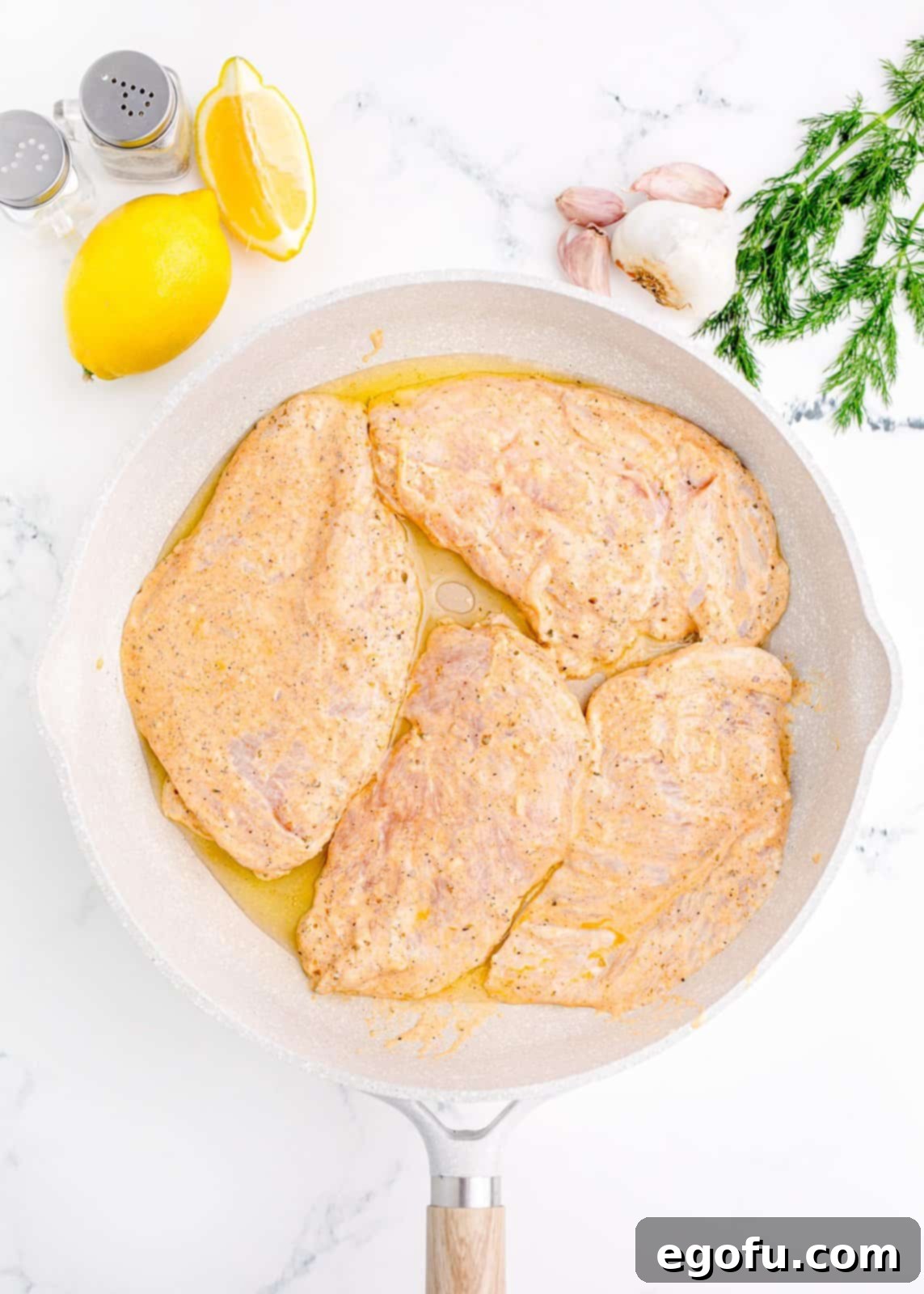 Marinated chicken cooking in a pan, showing a nice sear.