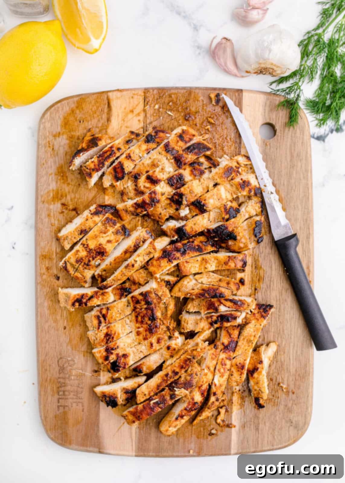 Cooked chicken cut into strips on a cutting board, ready for assembly.
