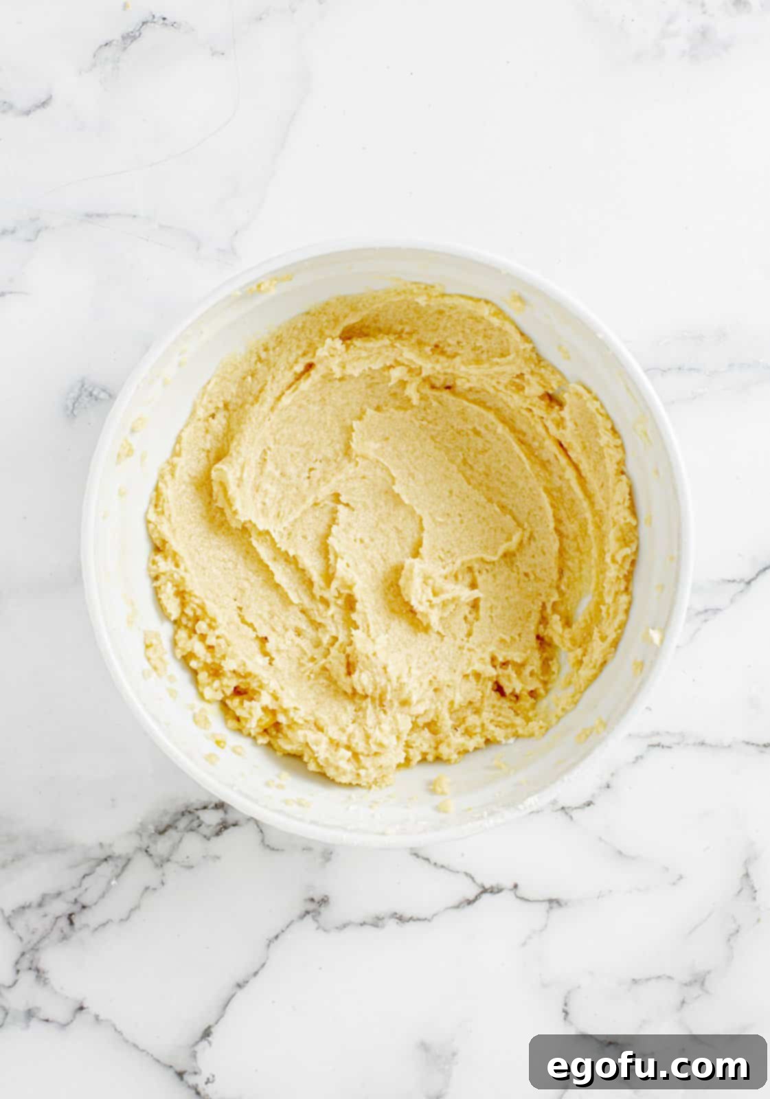 Softened butter, granulated sugar, brown sugar, egg, and vanilla extract expertly creamed in a mixing bowl.