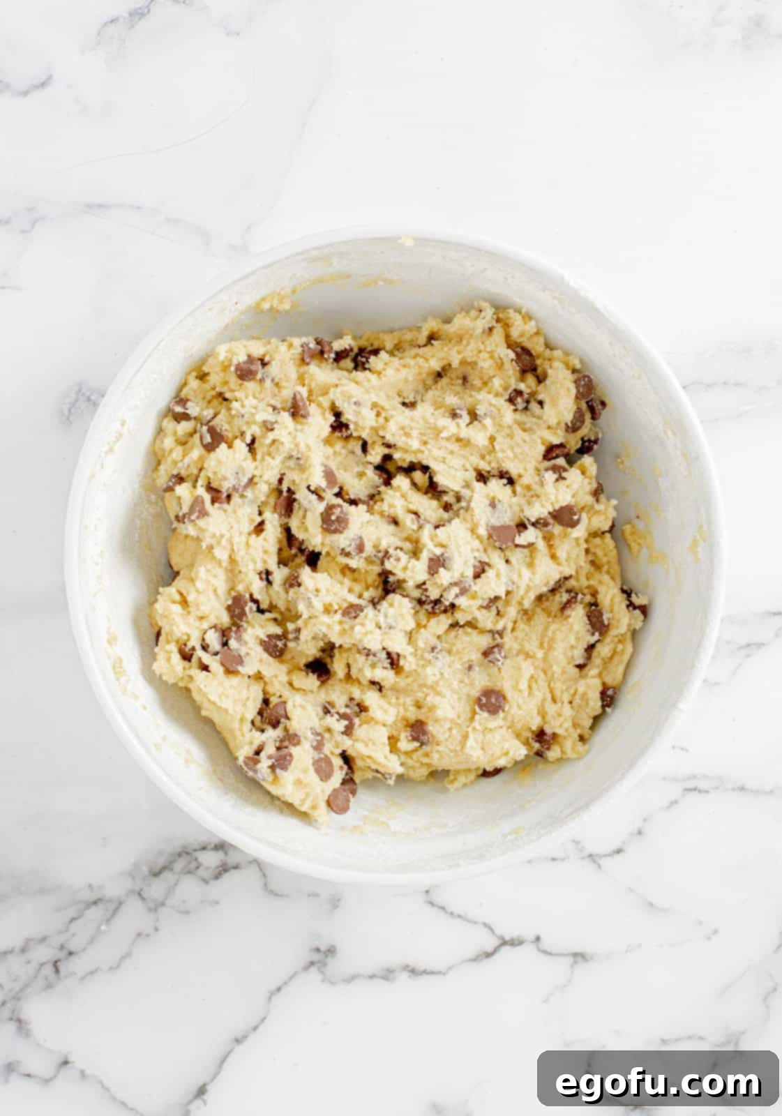 Cookie dough with chocolate chips mixed in, ready for chilling.