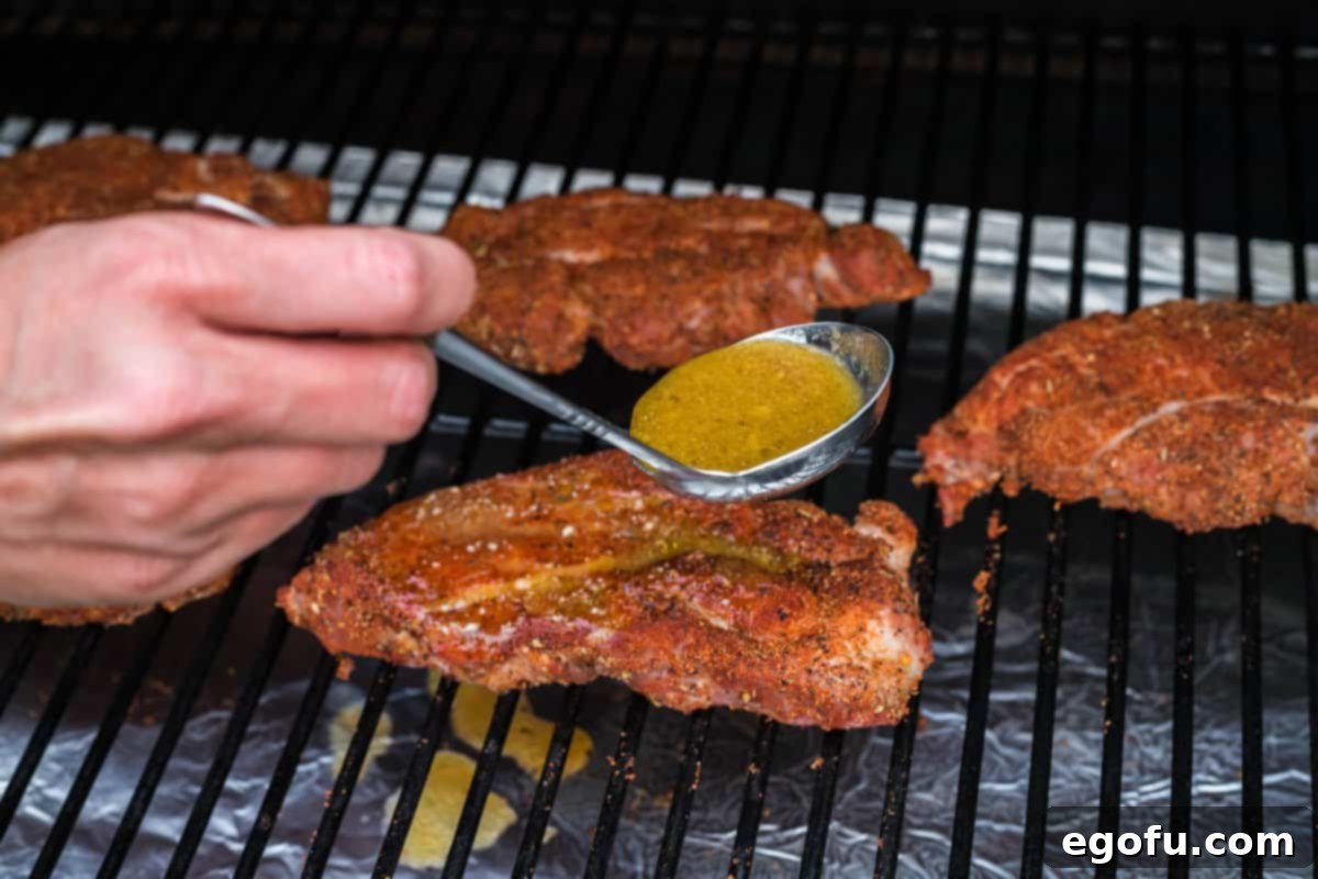 Apple cider mixture being drizzle over pork steaks.