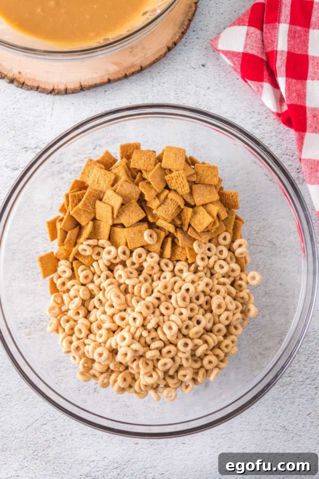 Both Honey Nut Cheerios and Golden Grahams cereal added to the bowl with the sticky peanut butter mixture.