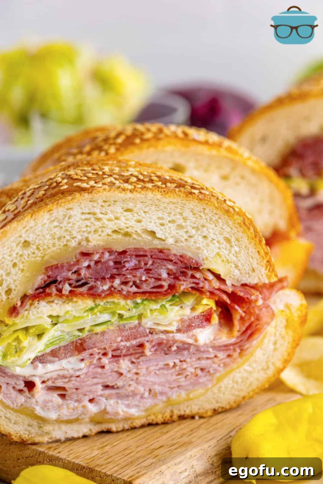 closeup photo of an Italian Grinder Salad Sandwich on a wood cutting board.