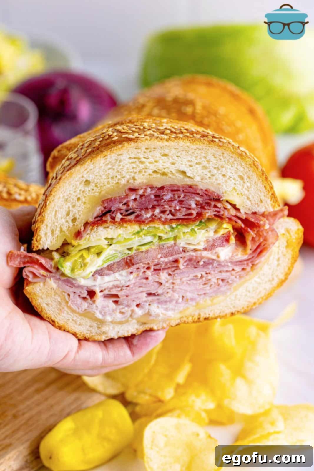 a hand holding up a slice of an Italian grinder sandwich.