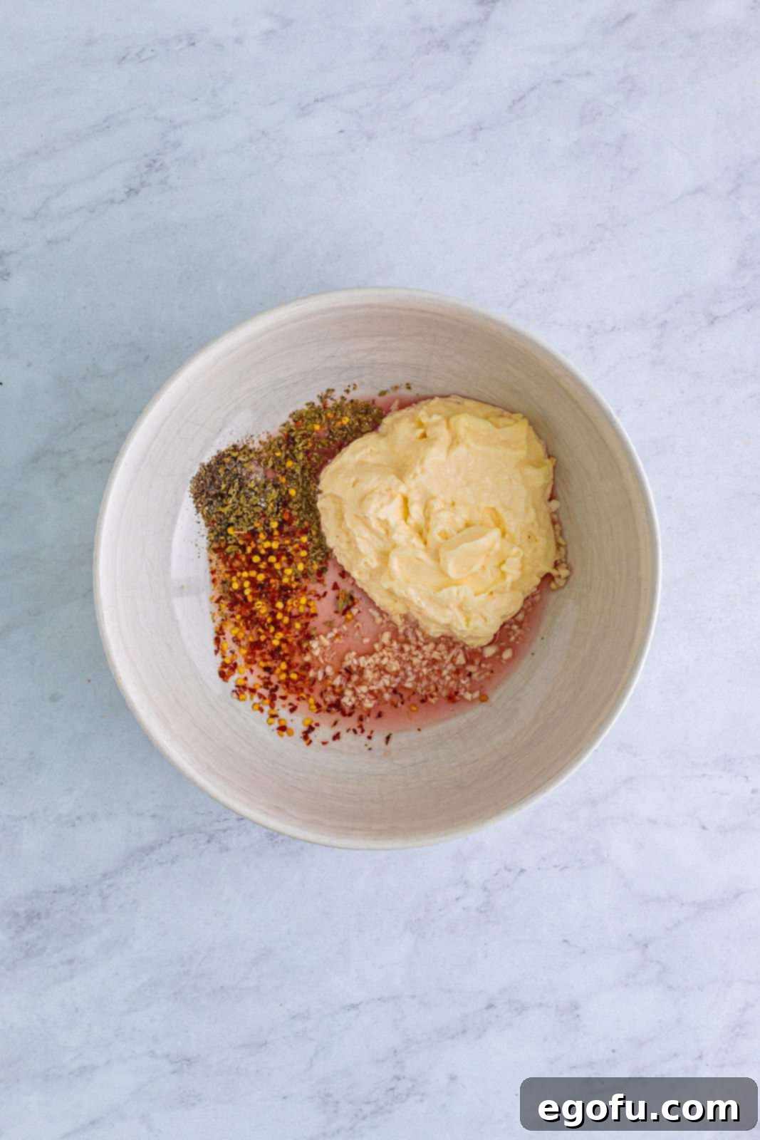 mayonnaise, red wine vinegar, garlic, pepper, oregano, chili flakes and salt in a white bowl.