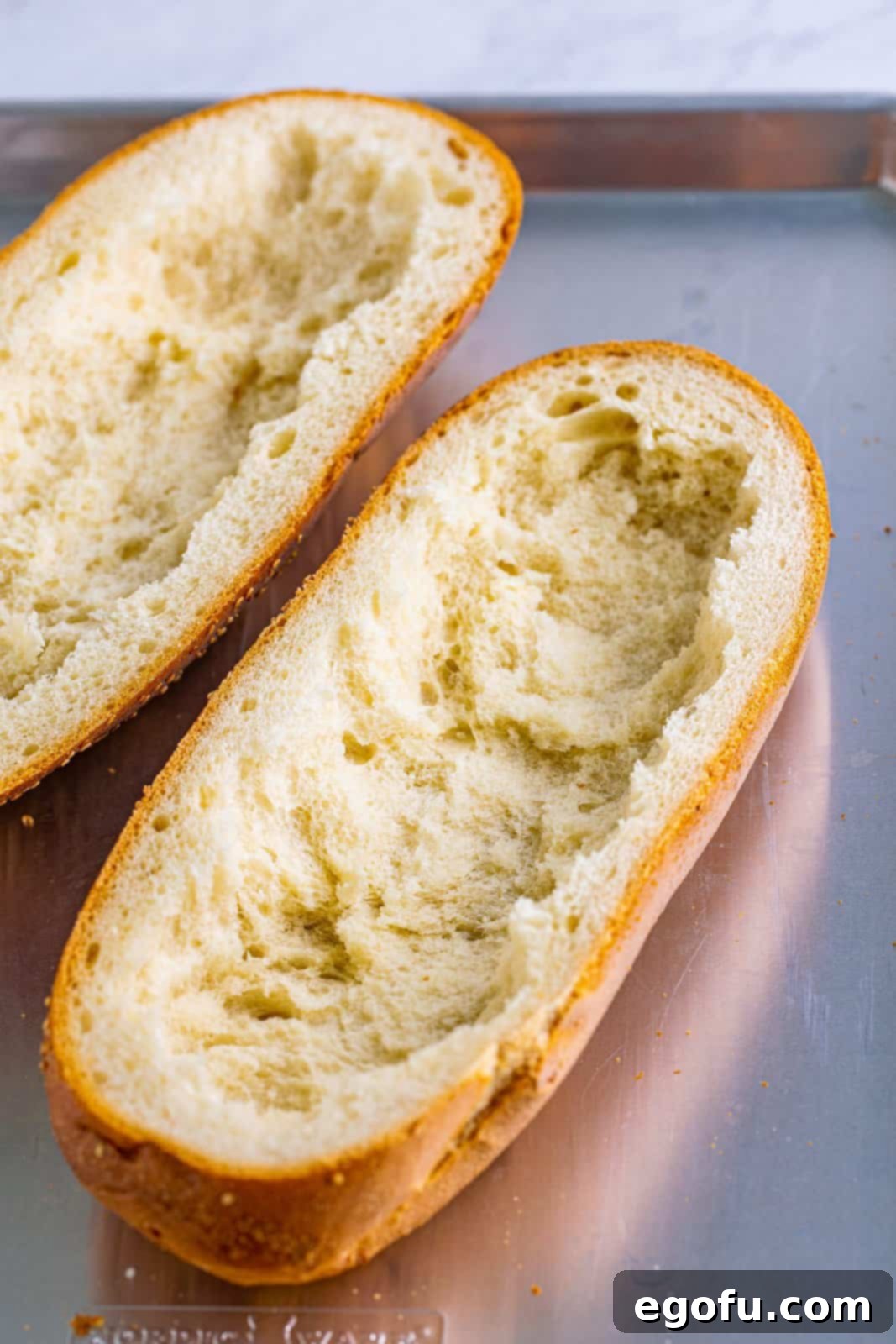 sliced sub bread with the middle part of the bread removed.