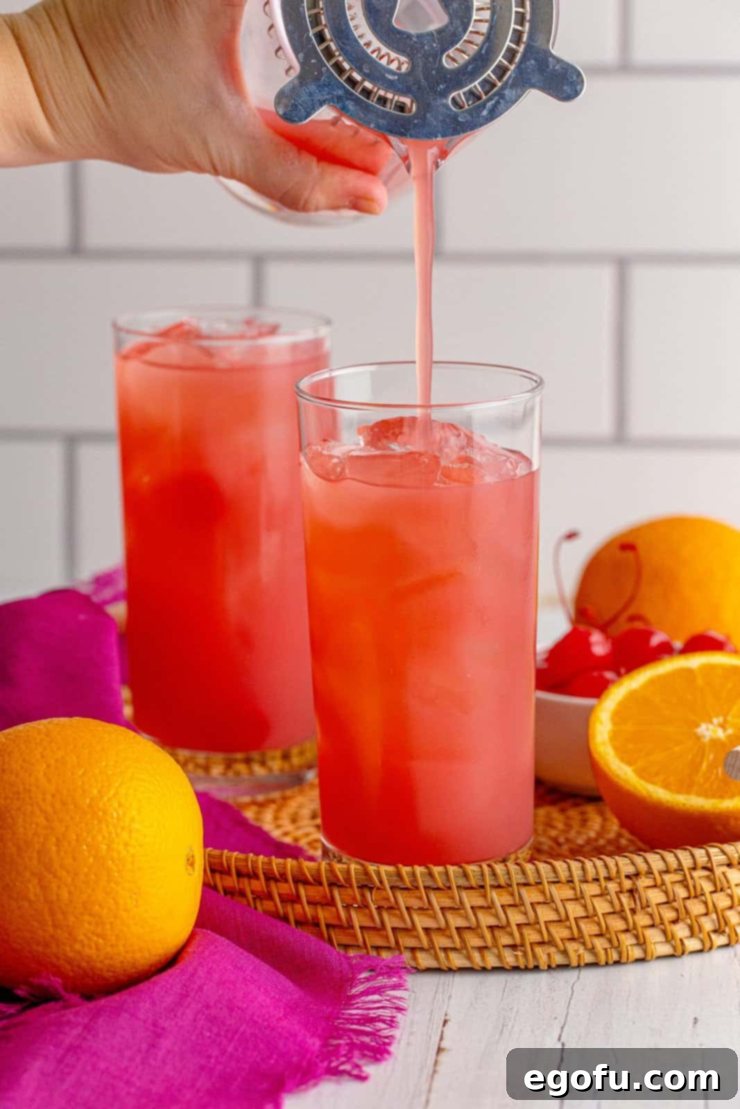 Coastal Affair Concoction 6 Mixed cocktail being poured into glass, ready for garnishing and serving.