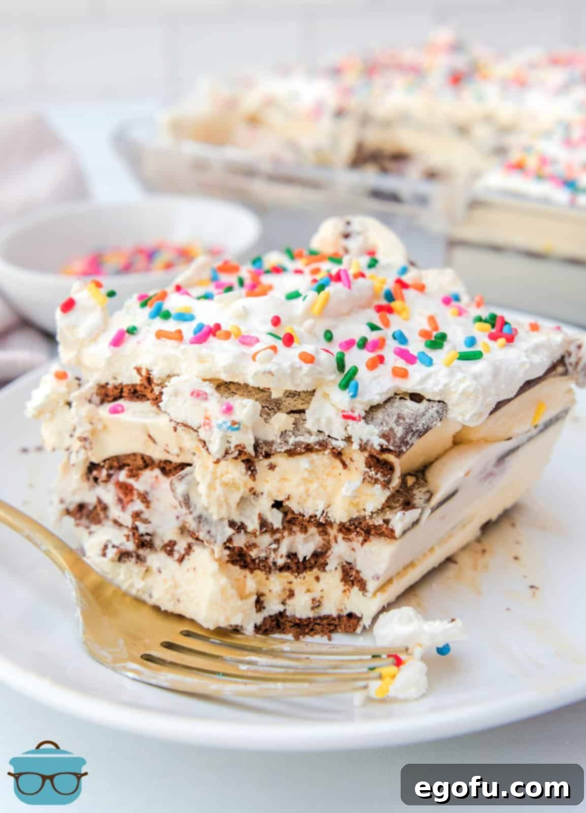 Slice of Ice Cream Sandwich Cake on white plate with bite taken out of it.
