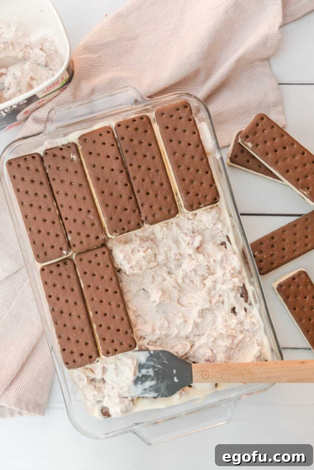 Second layer of ice cream sandwiches added to top of spread out ice cream.