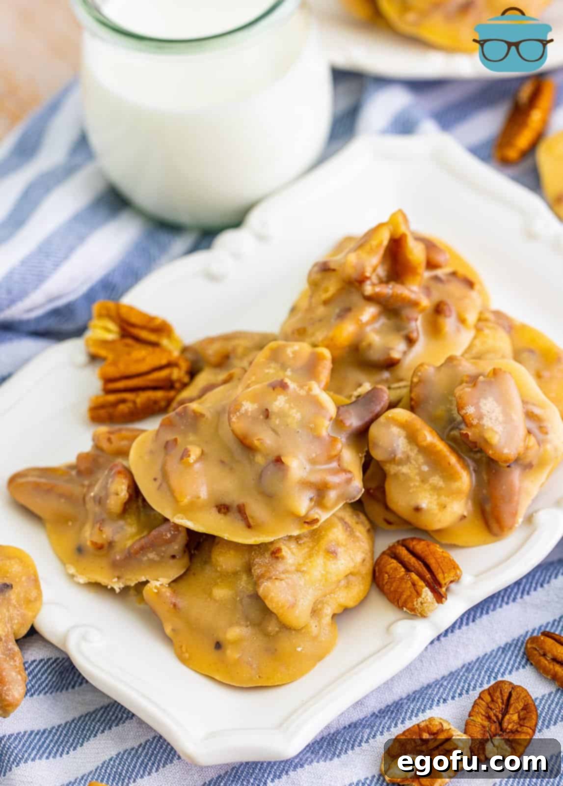 Decadent Southern Pecan Pralines 11 Overhead of stacked Southern Pecan Pralines on white platter with milk in background.