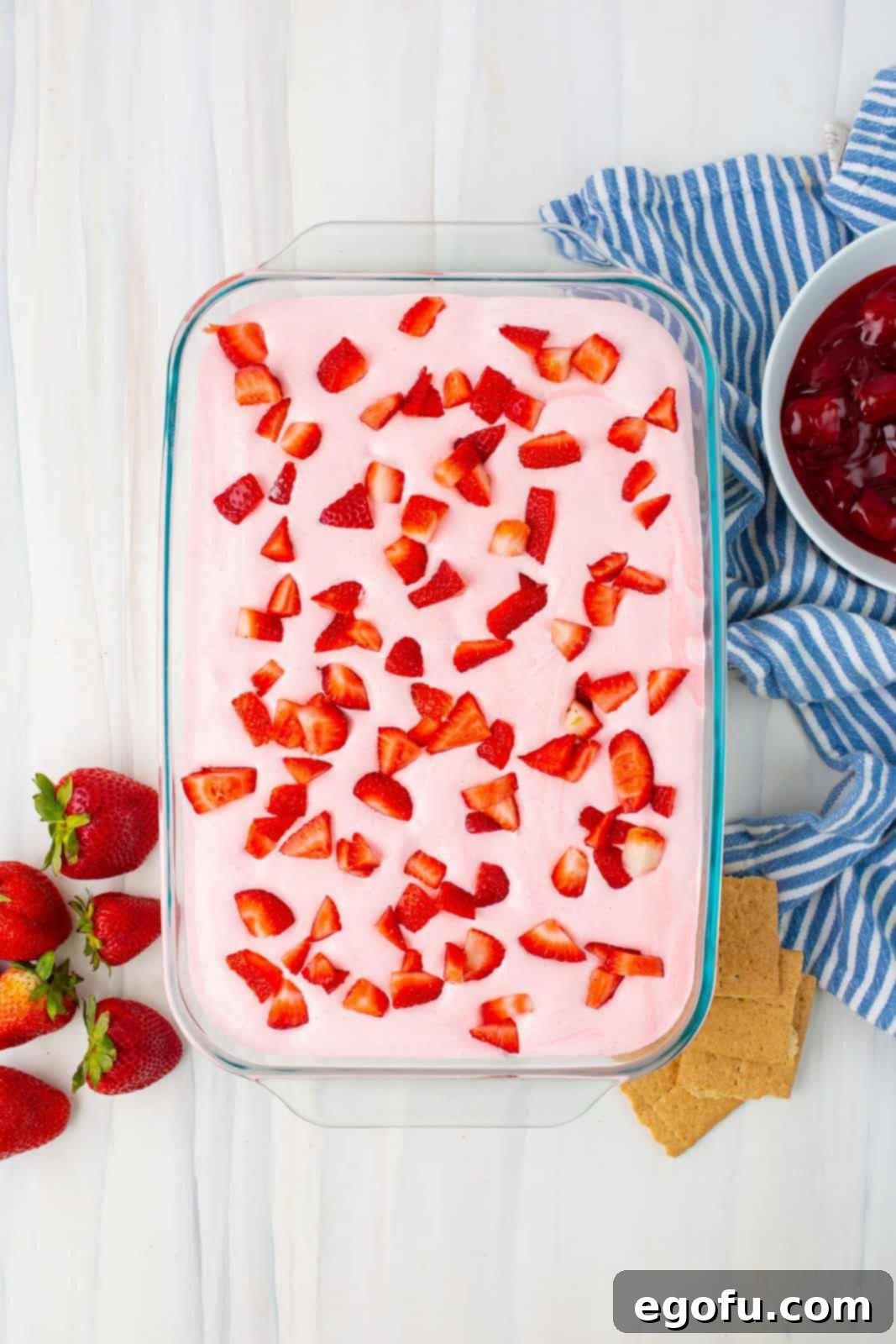 Finely chopped fresh strawberries generously added to the very top of the strawberry mixture, providing a fresh garnish and extra fruit flavor.