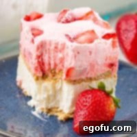 Close up image of a slice of Strawberry Icebox Cake on a blue plate, showing a bite taken out, perfect for Pinterest.