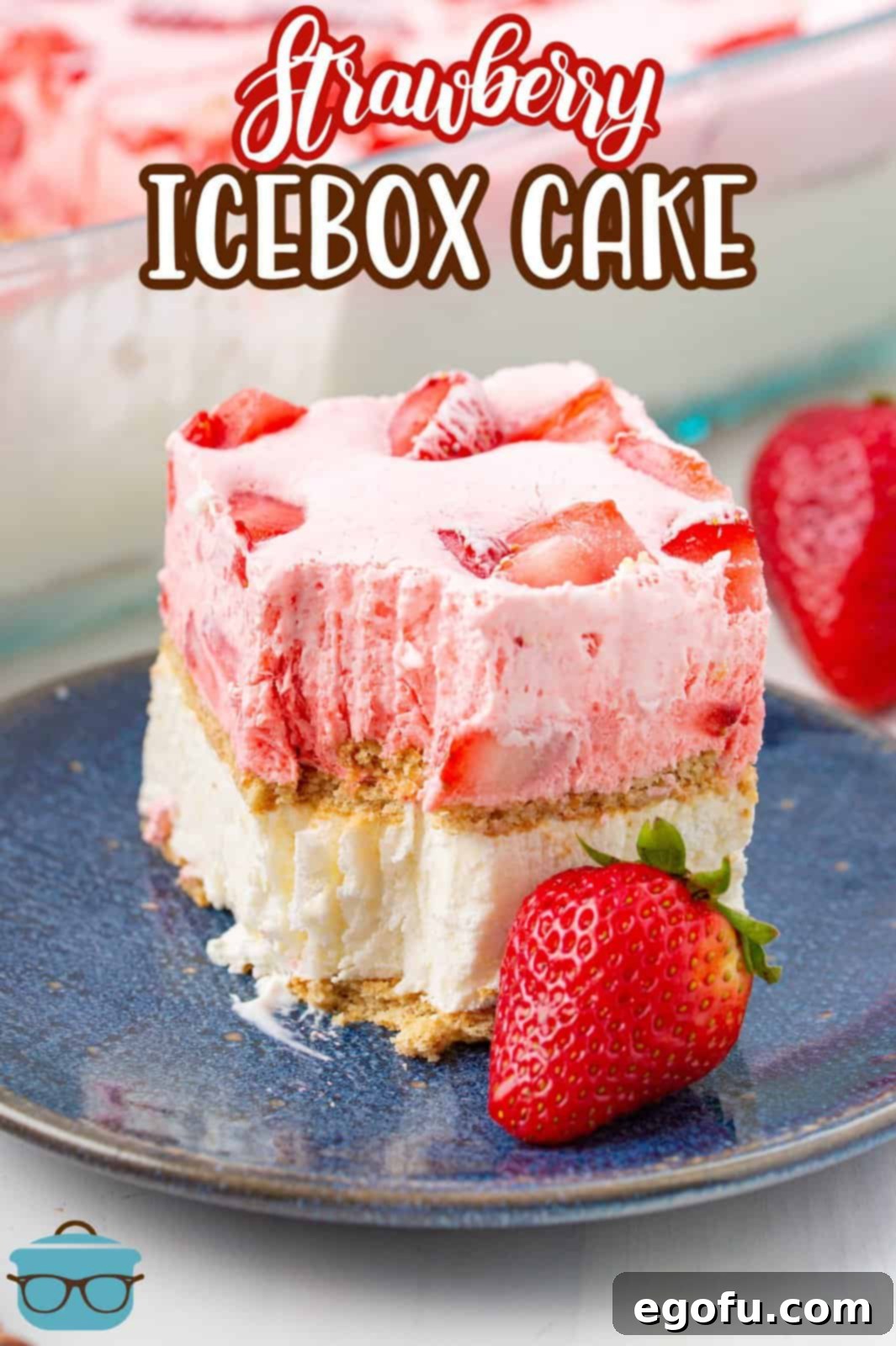 Another enticing slice of Strawberry Icebox Cake, perfectly layered, on a plate alongside a fresh strawberry, ready to be enjoyed.