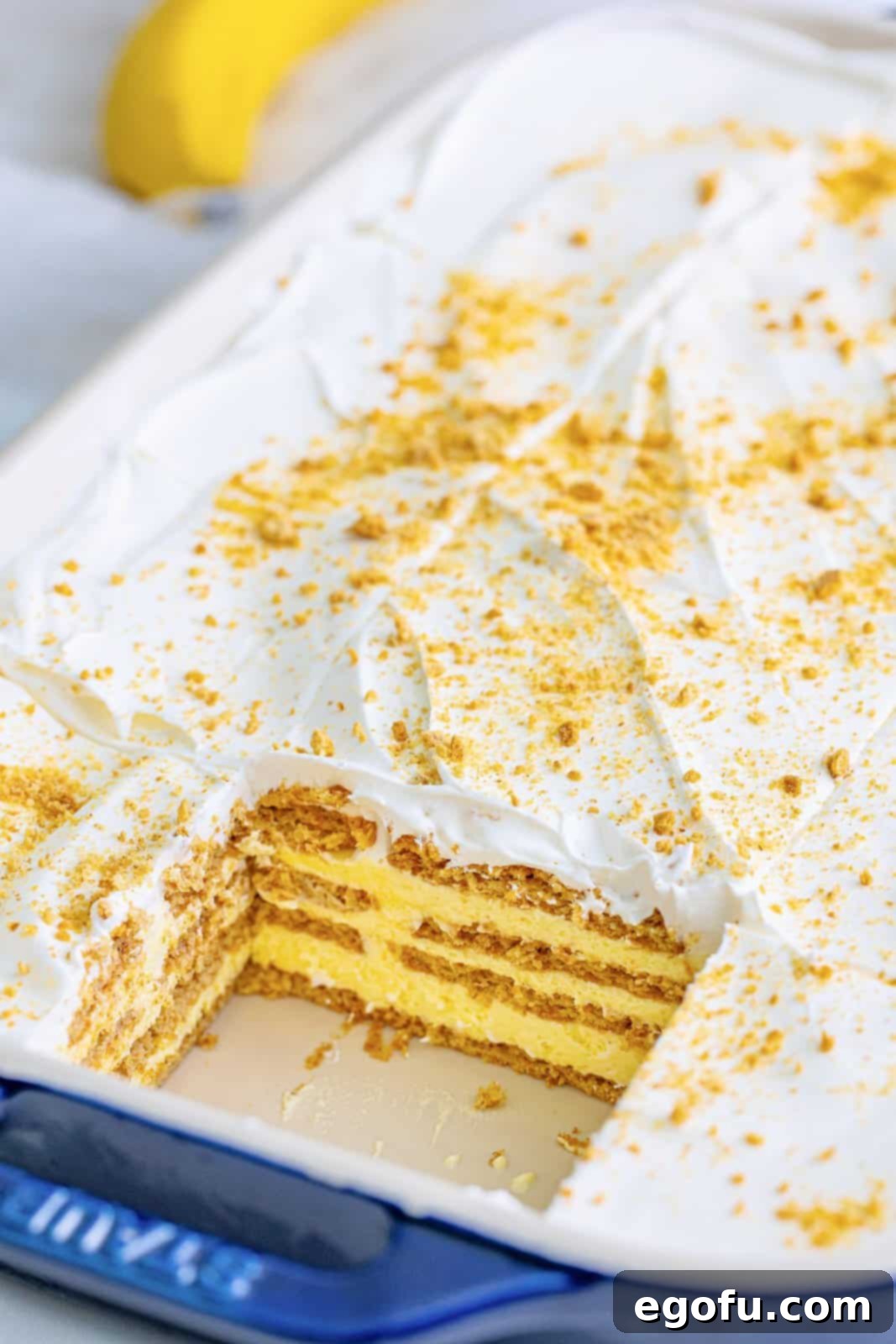 A delightful Banana Icebox Cake in a 9x13-inch pan with a clean slice removed, revealing its appealing layers, ready to be served.