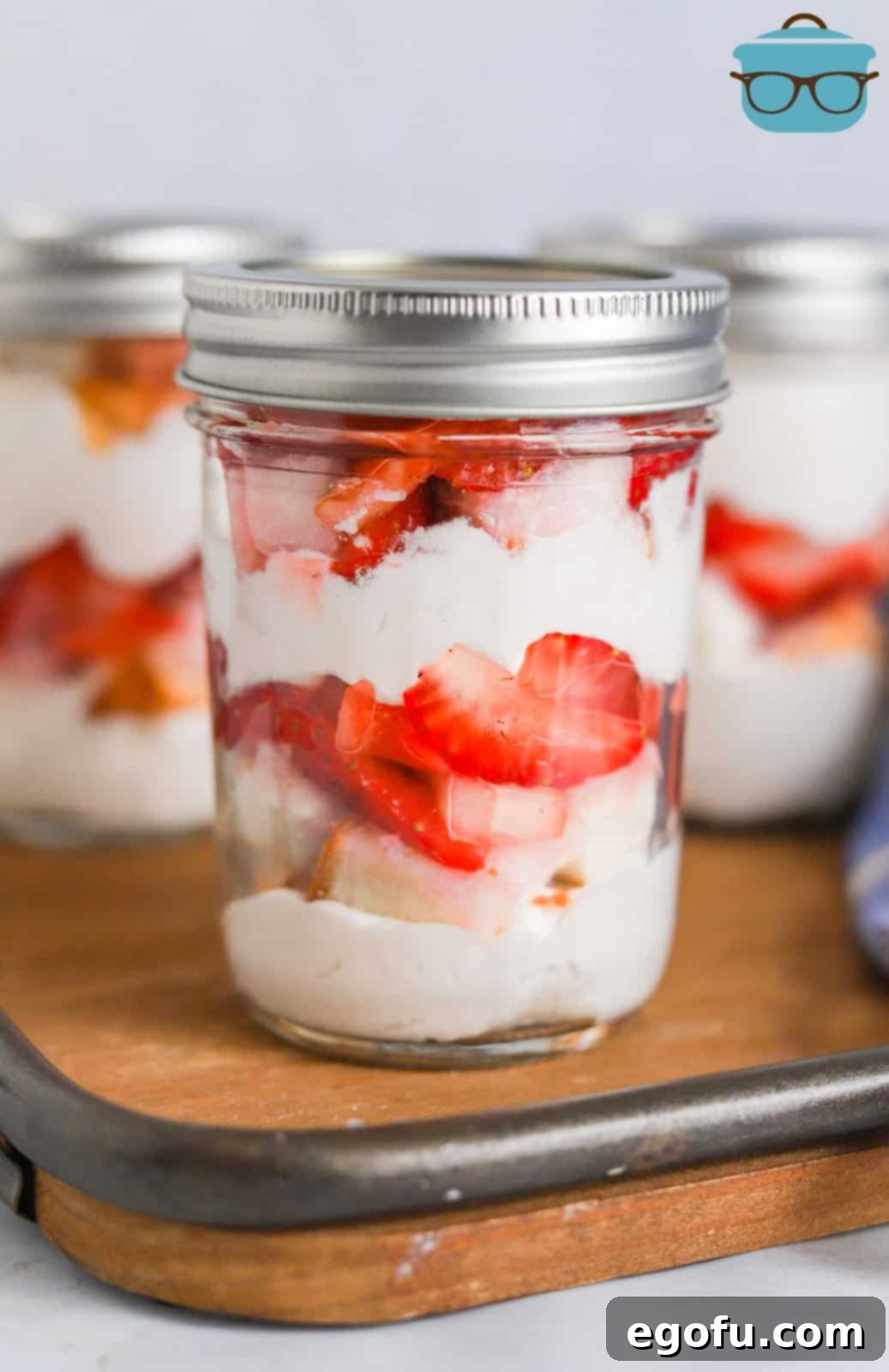 Strawberry Shortcake Jar Delights 14 Strawberry Shortcake in a Jar on wooden board with lid on top.