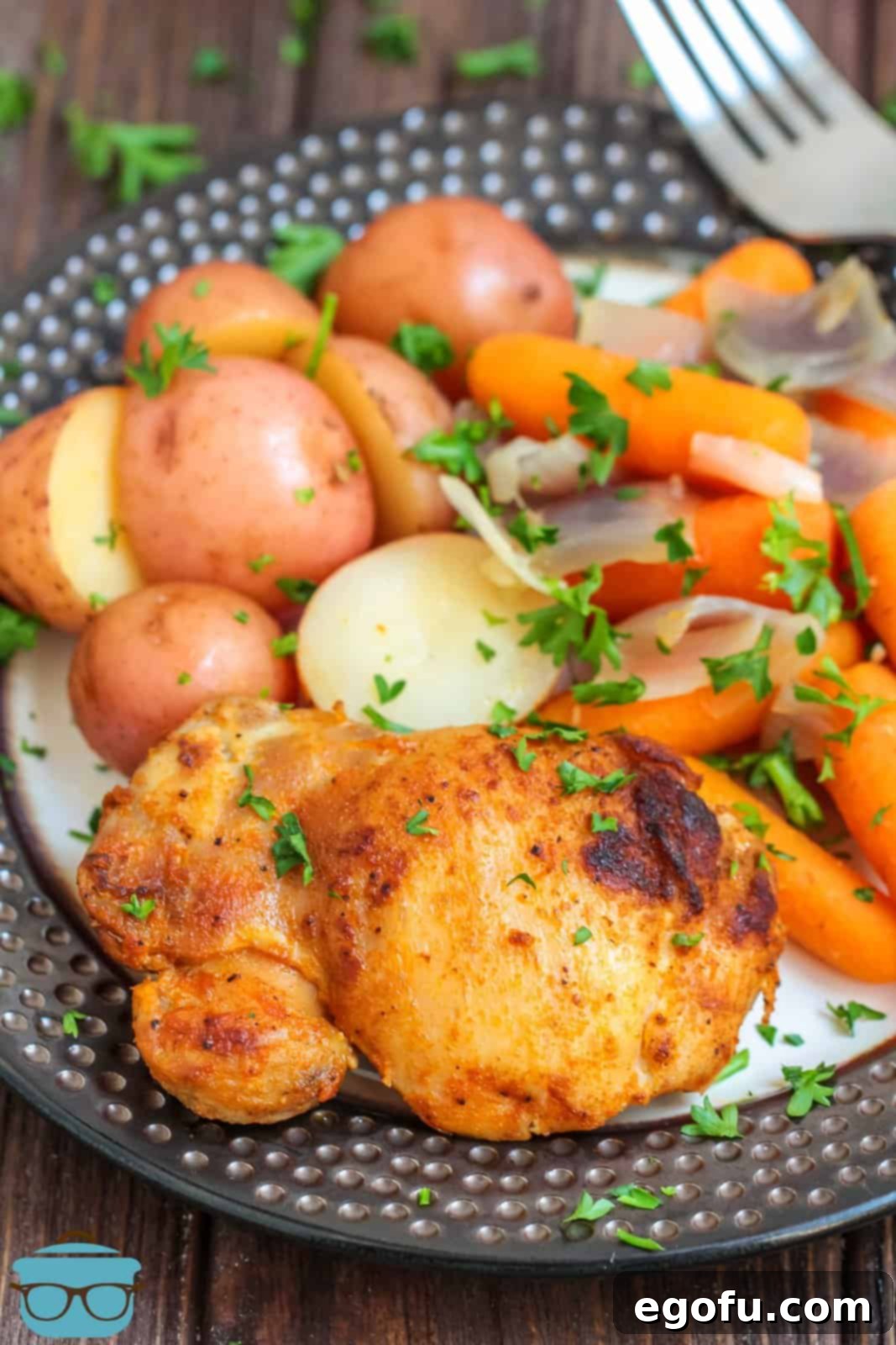 Slow Cooker Chicken Thighs Meal on plate ready to eat, garnished with fresh parsley.