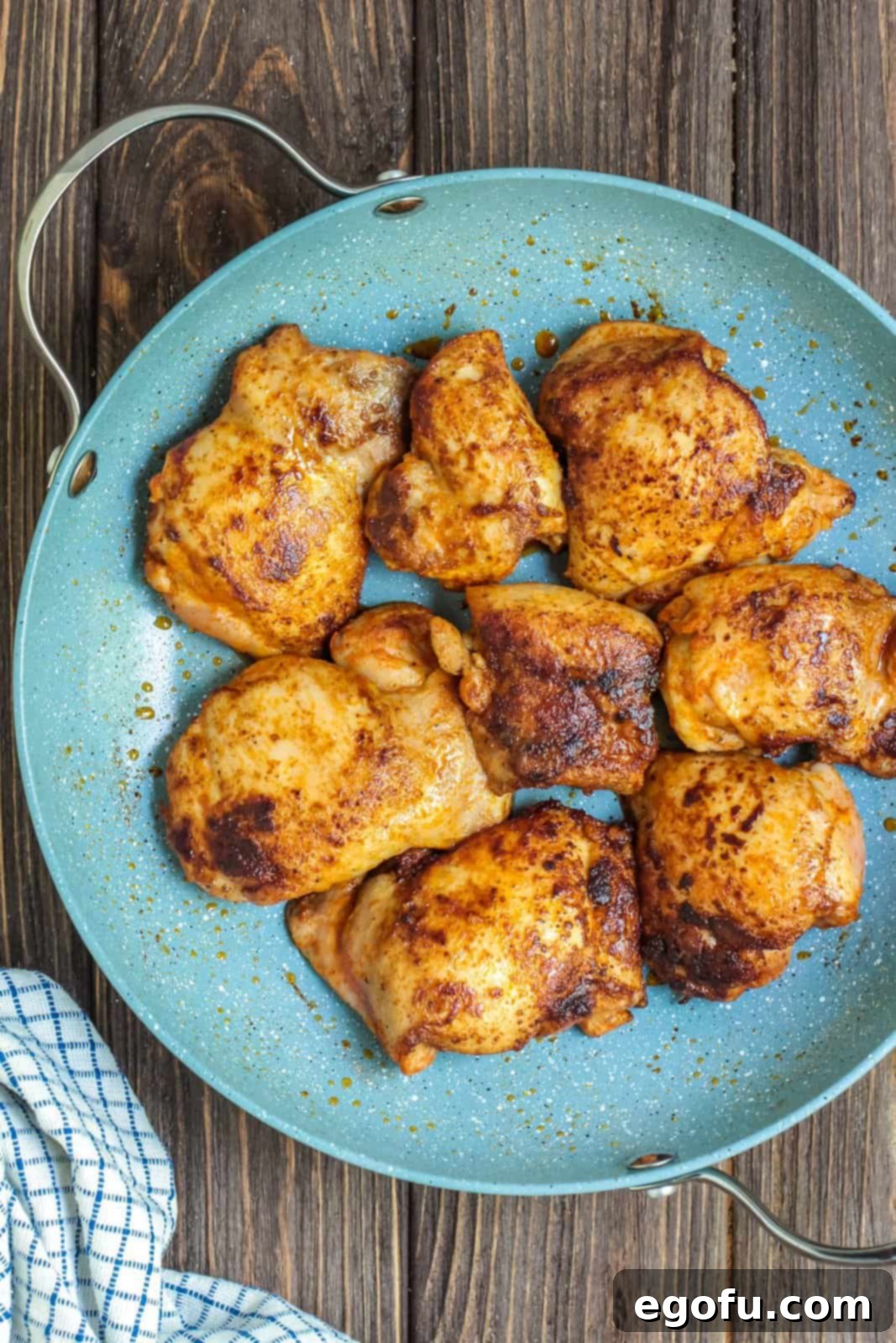 Chicken thighs being browned in a pan over medium-high heat.