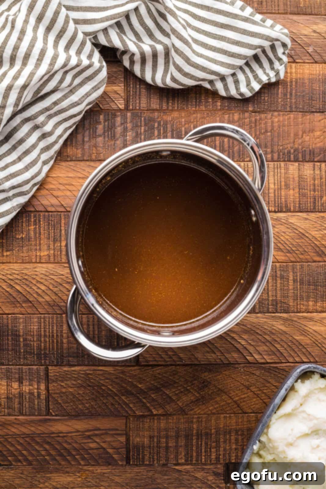 Pitmaster's Smoked Rump 12 The savory pan drippings from the smoked roast being heated to a boil in a saucepan on the stove.
