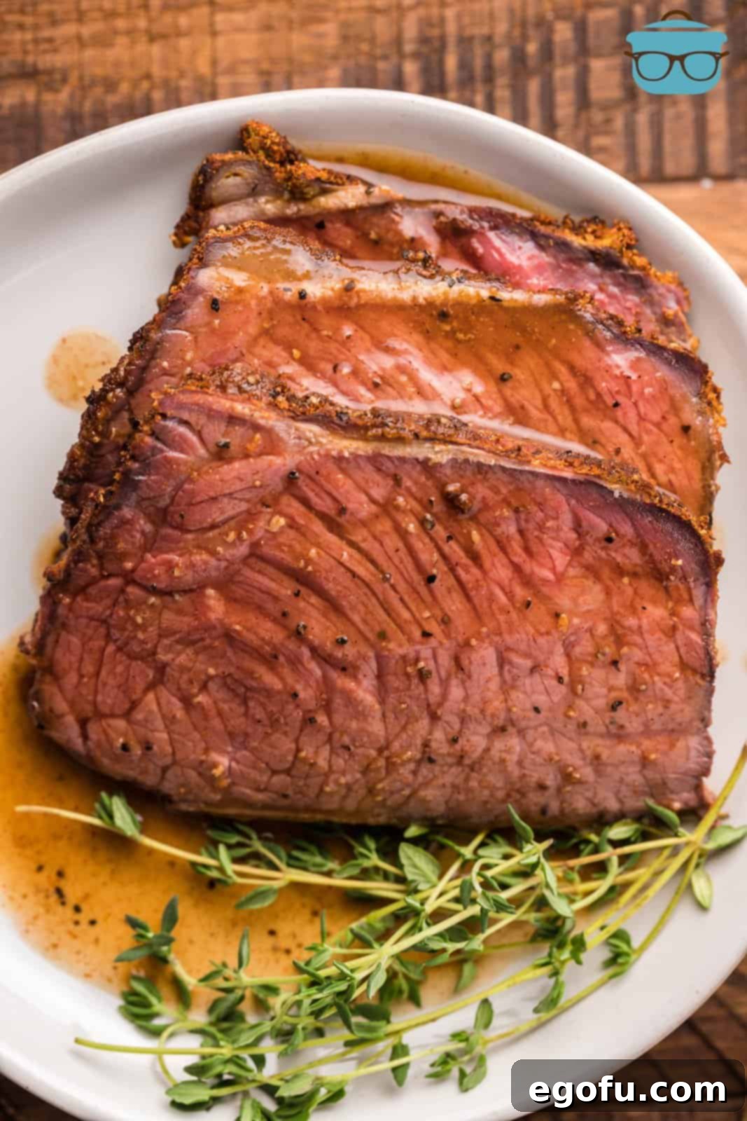 Pitmaster's Smoked Rump 14 Close-up overhead view of individual slices of Smoked Rump Roast on a plate, generously drizzled with savory pan sauce.