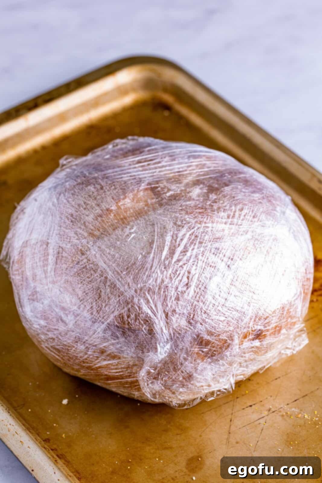 New Orleans' Signature Stack 12 Sandwich wrapped up tightly in plastic wrap.