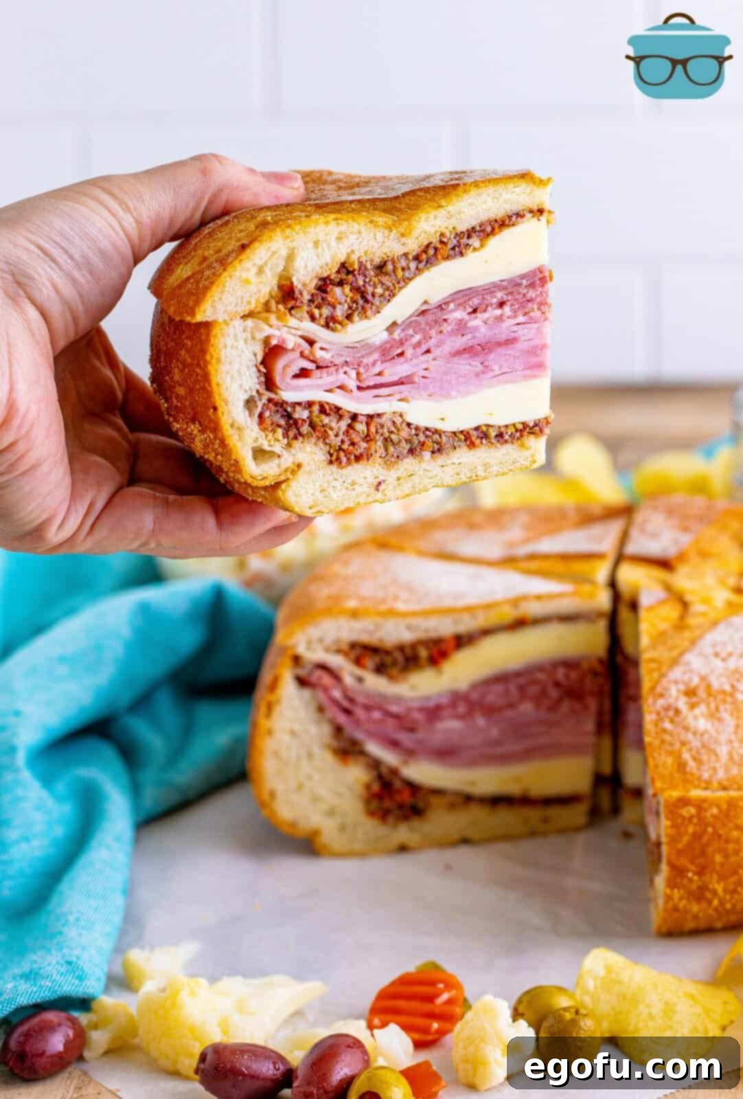 New Orleans' Signature Stack 13 Hand holding up one slice of the Muffaletta Sandwich.