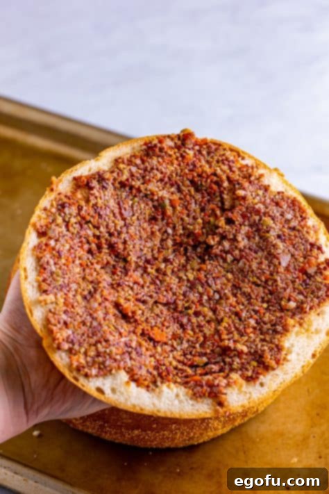 New Orleans' Signature Stack 21 Remaining olive spread spread over the top of the bread round.