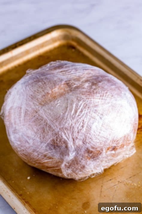 New Orleans' Signature Stack 22 Sandwich wrapped up tightly in plastic wrap.