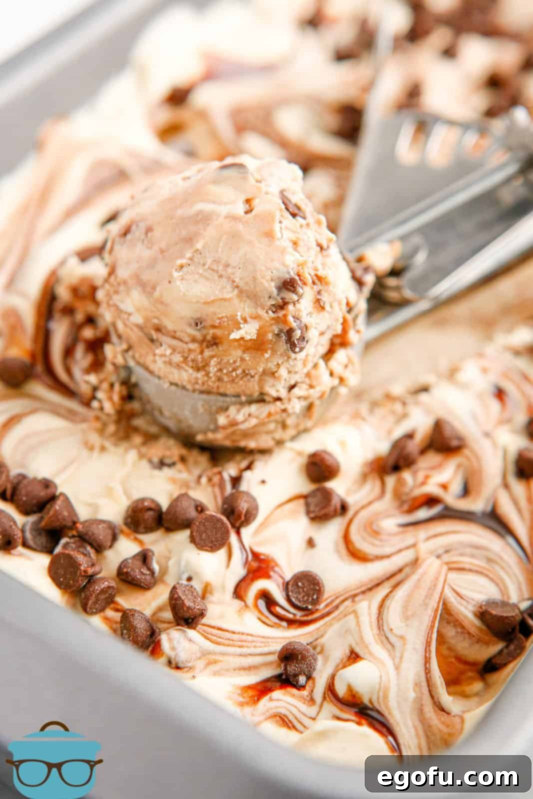 No-Churn Peanut Butter Chocolate Chip Ice Cream in pan with ice cream scoop holding some of the ice cream.