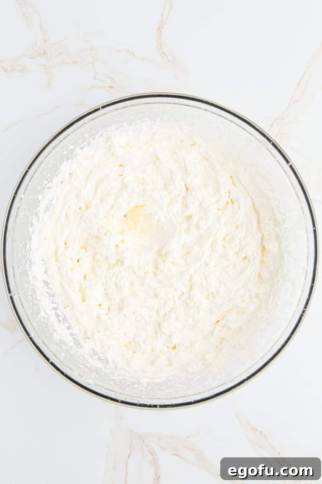 Beaten whipped cream in bowl.