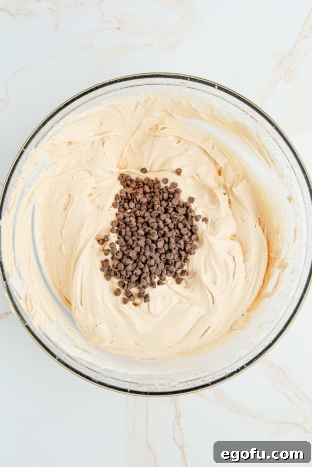 Chocolate chips being added to mixture in bowl.
