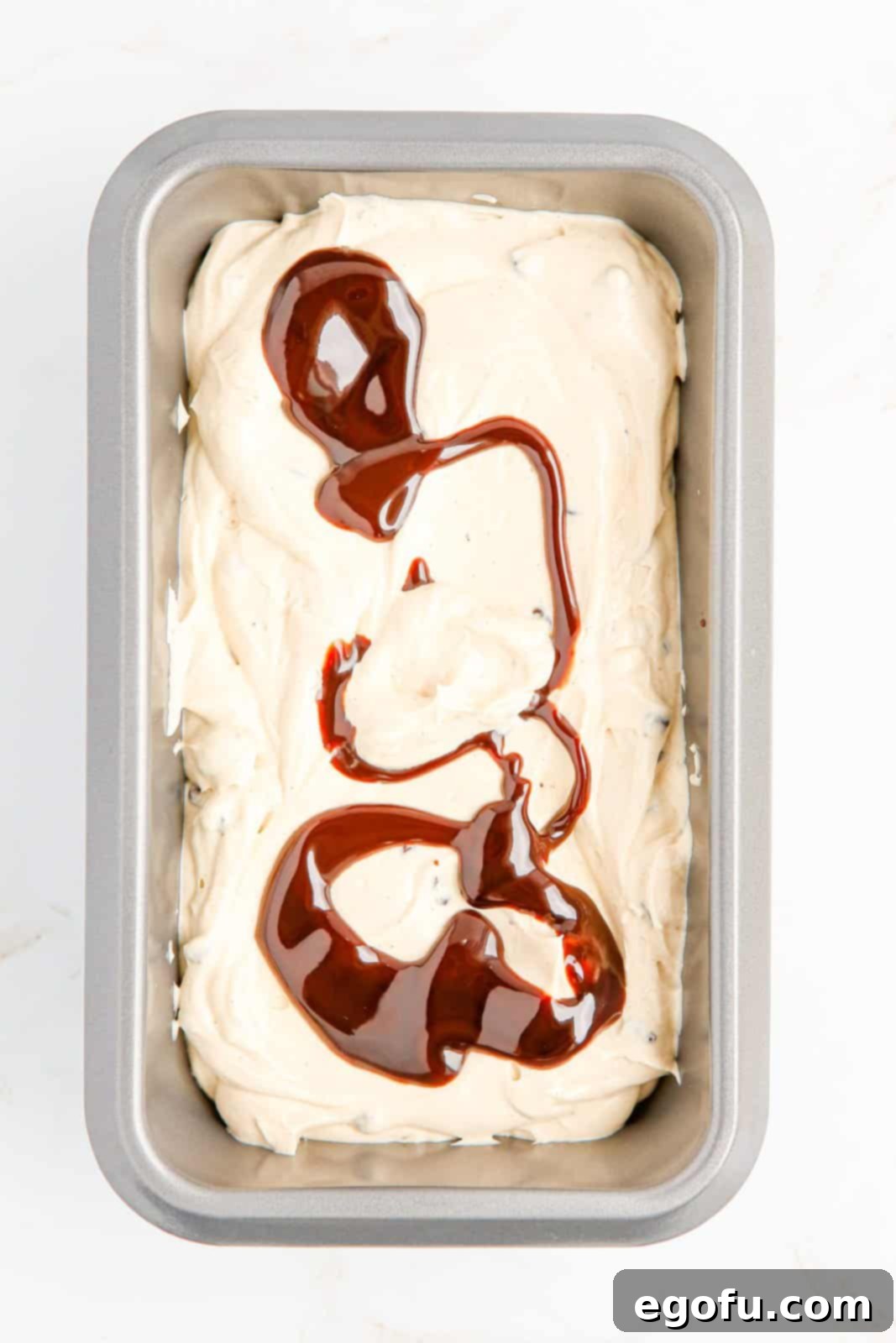 Ice cream being layered in pan.