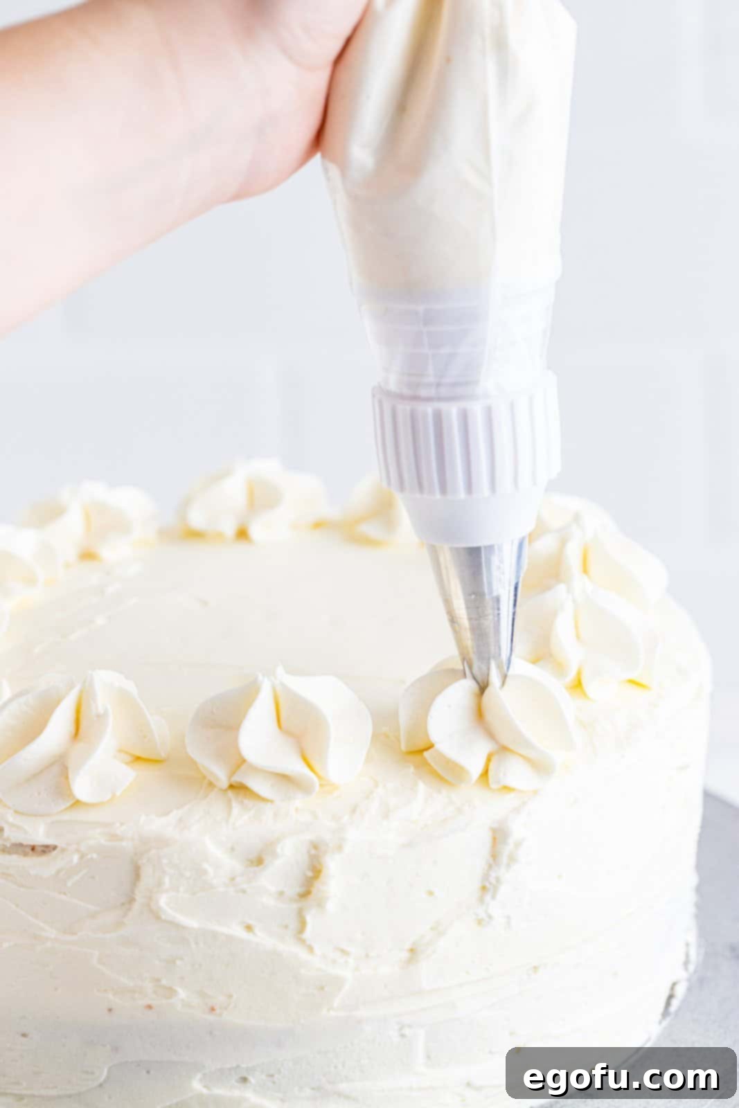 Zesty Lemon Dream Cake 18 Cake being finished frosted and decorated.