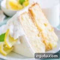 Zesty Lemon Dream Cake 21 Close up square image of slice of Lemon Layer Cake on white plate.