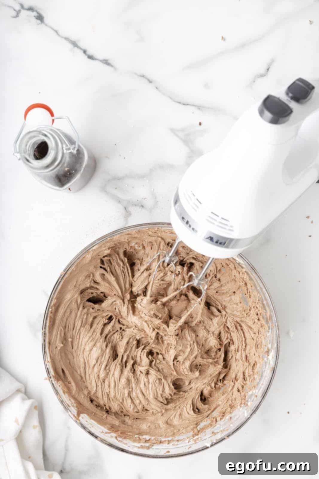 The rich, fluffy chocolate marshmallow frosting is beautifully made and sitting in the mixing bowl.