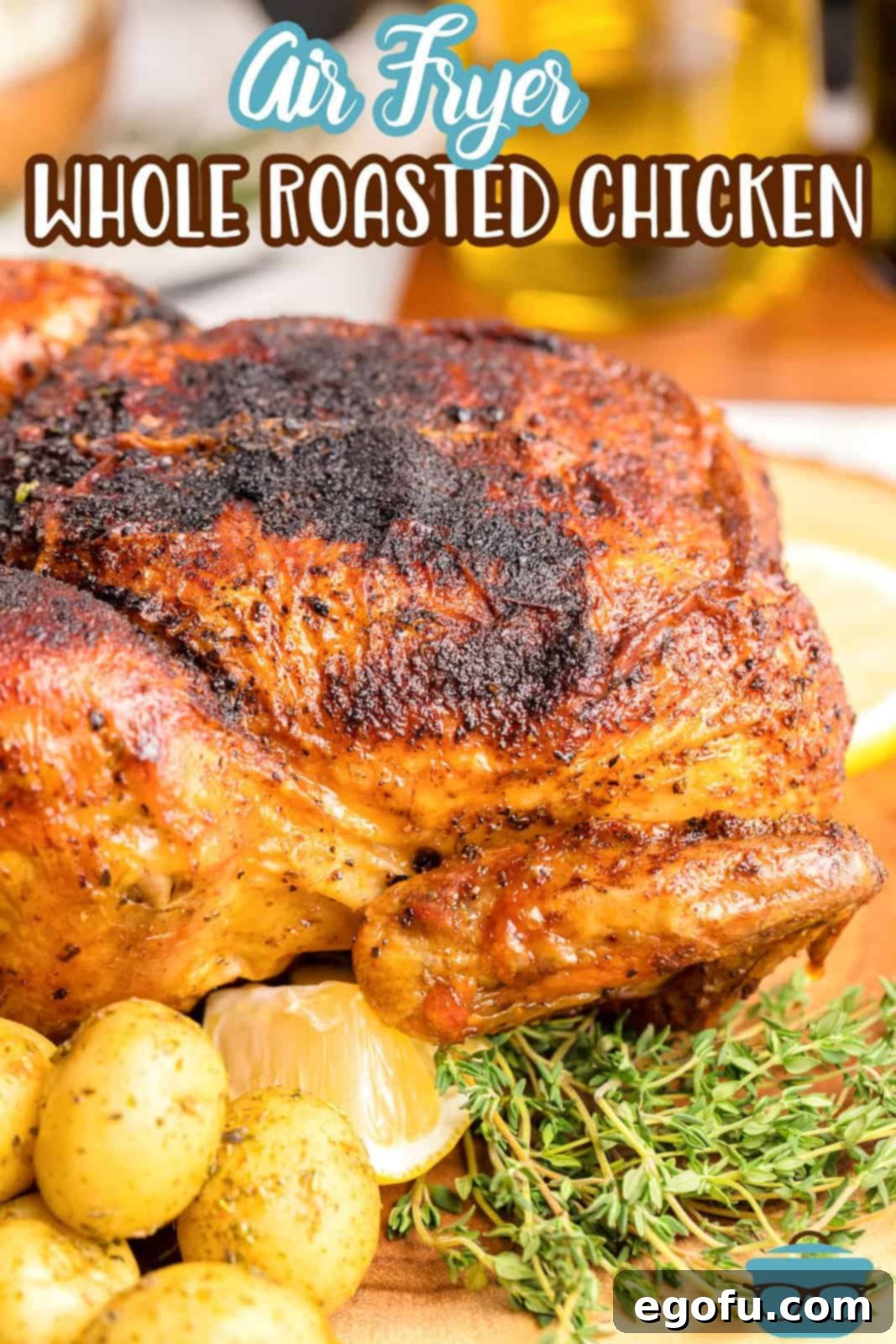 Beautifully presented Air Fryer Whole Roasted Chicken with a sprig of rosemary, sliced lemon, and golden potatoes, perfect for a Pinterest share.