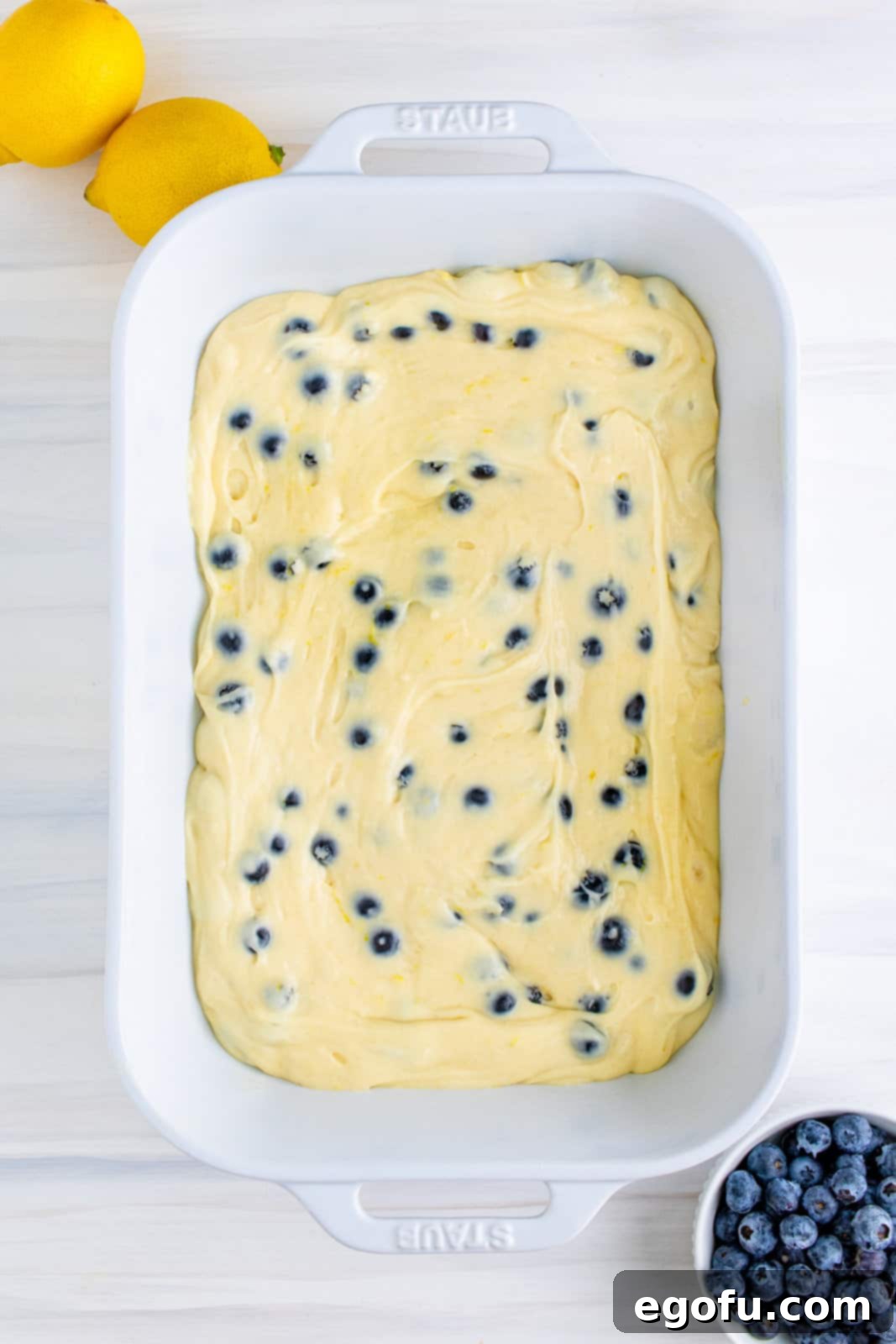 Half of cake batter spread in bottom of baking dish.
